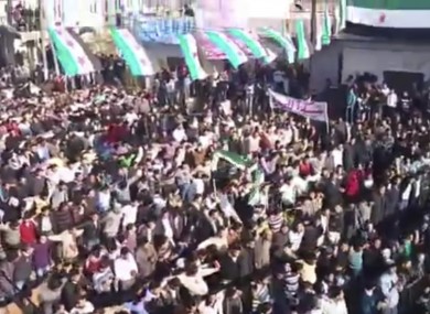 In this image from amateur video made available by the Ugarit News group and shot on Friday, Dec. 30, 2011, protesters gather at an anti-Bashar Assad rally in Hama, Syria.
