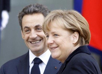 French President Nicolas Sarkozy, left, smiles as he greets German Chancellor Angela Merkel prior to their meeting at the Elysee Palace in Paris, Monday Dec. 5, 2011