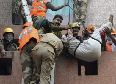 Rescue workers evacuate people from the hospital during today's fire.