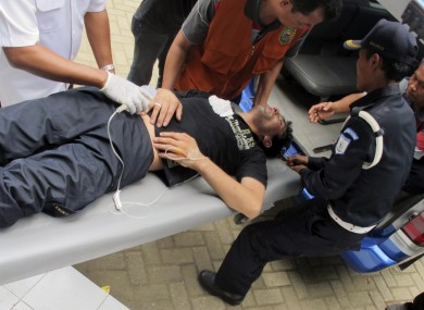 One survivor is loaded into an ambulance on Java