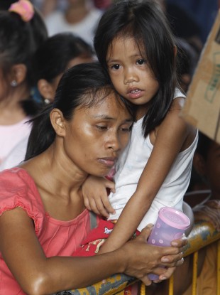 Residents queue up for relief supplies being distributed at an evacuation centre yesterday