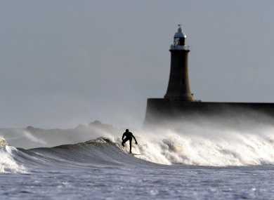 A surfer makes use of the strong North Sea waves at Longsands Beach in Tyne and Wear, north-east England earlier today.