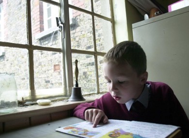 A 6-year-old student reading beside a broken window in a school in Phibsboro, Dublin (File photo)