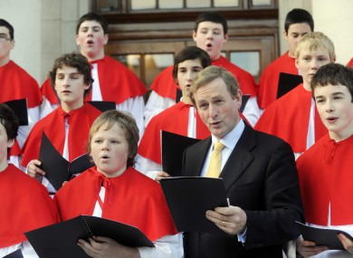 Taoiseach Enda Kenny sings with members of the Cistercian College orchestra and choir at Government Buildings this afternoon.