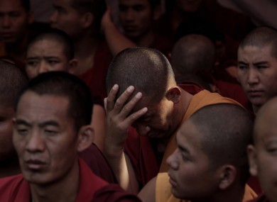 A Tibetan exile monk holds his head as he takes part in a day-long hunger strike in New Delhi, India, to express solidarity with the plight of the people in Tibet, Tuesday 18 October 2011.