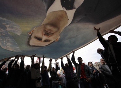 Bashar Assad supporters wave a banner with his likeness in Damascus last week.