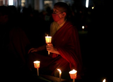 A Tibetan Buddhist monk holds a candle during a candlelit vigil for Tibetans who self-immolated in Tibet, in Bodh Gaya, Bihar state, India, Sunday, Jan. 8, 2012