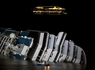 The cruise ship Costa Serena passes its sister ship Costa Concordia lying off the Italian coast.