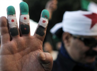 An anti-Syrian regime protester colors his fingers with the revolutionary flag colors during a protest outside the Arab League headquarters in Cairo, Egypt, last Sunday
