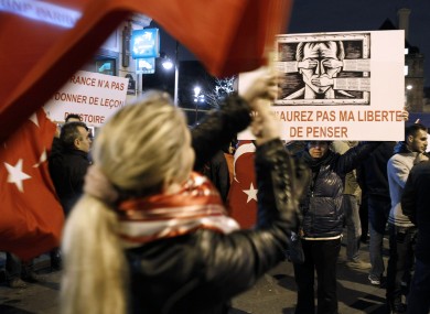 A woman holds a banner which says