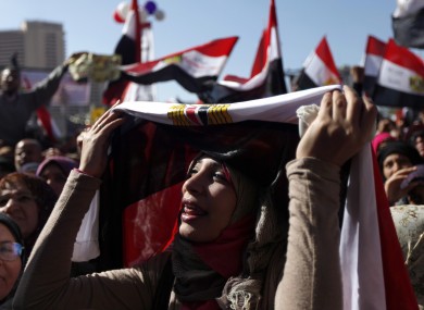 A female Egyptian protester chants slogans and holds a national flag at a rally to mark the first anniversary of the
