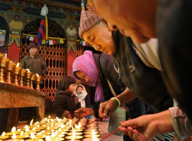 Tibetan Buddhist exiles offer prayers and light candles in solidarity with Tibetans protesting against Chinese rule.