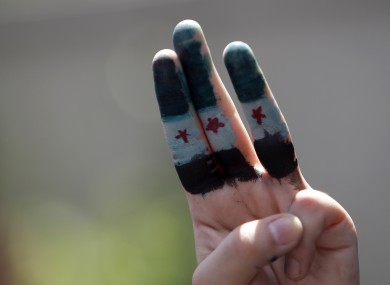 A Syrian living in Malaysia with her fingers painted with Syrian flag takes part in a protest rally to condemn the killing by Syrian regime.