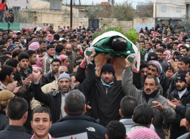 Anti-regime protesters in Syria cary the body of a man they claim was killed by government forces in Rastan, Homs.