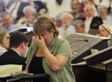 State representative Tammy Sommons covers her face after lawmakers rejected a bill which would have overturned previous laws allowing gay marriage.