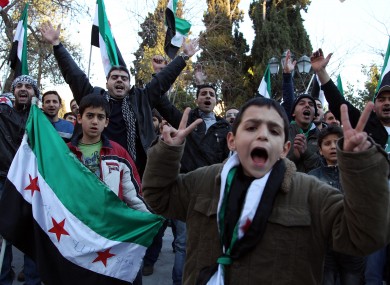 Syrian nationals who live in Greece shout slogans and wave the revolutionary Syrian flag during a protest in Athens today.