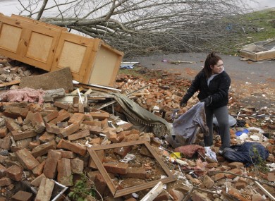 Hannah Rechel, from Dent, Ohio, helps recover personal items from debris after a tornado struck on Friday.
