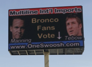 An electronic billboard located over a memorabilia store in north Denver urges fans to cast a ballot for either Peyton Manning, shown left, or Tim Tebow as the NFL quarterback for the Denver Broncos.