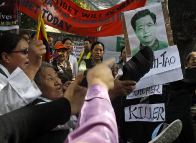 Tibetan exiles strike an image of Chinese President Hu Jintao during a demonstration in India on Saturday.