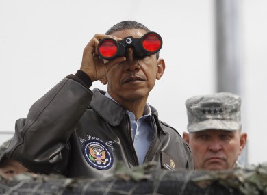 Obama looking through binoculars to see North Korea from the demilitarised zone today.
