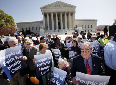 Protesters in favour of health care reform demonstrate outside of the Supreme Court in Washington today.