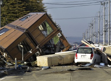 A man walks by a collapsed house and debris at Sendai Port in Sendai following last year's tsunami. New government reports say a similar quake could result in an even larger tidal wave.