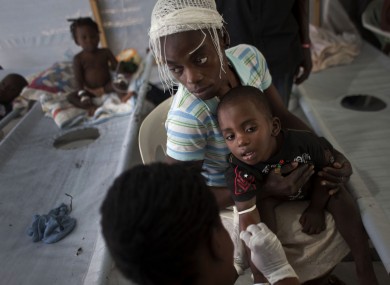 A woman holds her sick child as he receives treatment for cholera at a Doctors Without Borders, MSF, cholera clinic in Port-au-Prince, Haiti, last October.