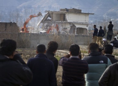 Media and locals watch as the Abbottabad compound Bin Laden was found in is demolished in February 2012.