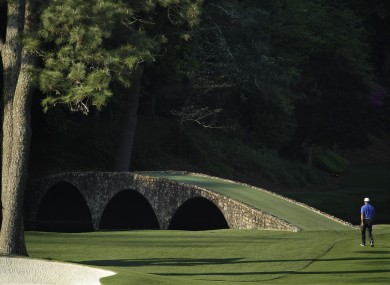 iger Woods walks towards the Ben Hogan Bridge on the 12th fairway during a practice round for the Masters.
