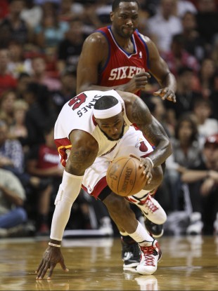 LeBron James, foreground, attempts to stay on his feet as he breaks for the basket trailed by Philadelphia 76ers forward Elton Brand.