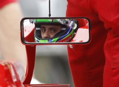 Ferrari F1 driver Felipe Massa looks out his rear-view mirror, as his team work on his car in the pit lane during practice for this weekend's Chinese Grand Prix in Shanghai.