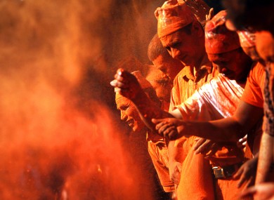Nepalese devotees throw vermilion powder on each other during Sindur Jatra festival in Thimi, on the outskirts of Katmandu, Nepal