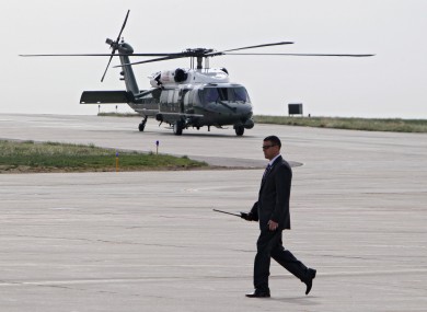 A Secret Service agent walks the tarmac as Marine One carrying Barack Obama takes off