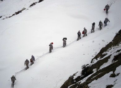 File photo of Pakistani soldiers bringing suppliers up the a mountain in February. 130 soldiers are thought to have been trapped by today's avalanche.