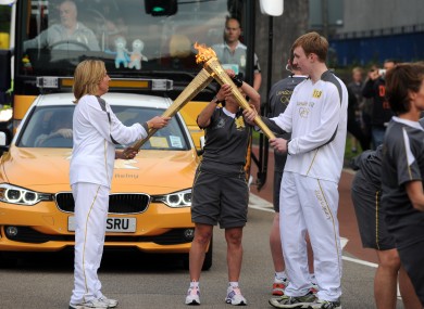 Torchbearers in Exeter pass the Olympic flame in Exeter yesterday, as the torch began its 8,000-mile trip around Britain and Ireland.