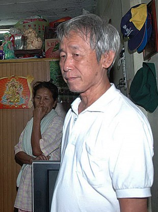 Amphon Tangnoppakul, right, pauses as he is arrested by Thai police