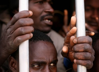 In this Saturday, Feb. 24, 2012 photo, illegal African migrants and suspected mercenaries stand in a prison in Gherian, Libya