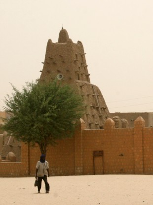 a man walks past the Sankore Mosque, a UNESCO World Heritage Site, in Timbuktu, Mal