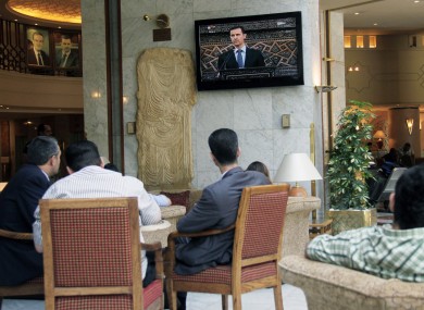 People watch Syrian president Bashar Assad deliver a live speech in Damascus, Syria, earlier today.