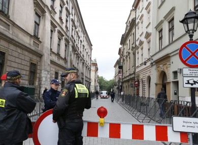 Security personnel keep guard at the entrance to the street where the England team hotel is located in Krakow.