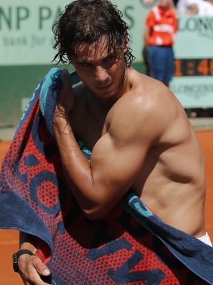 Spain's Rafael Nadal wipes his body after defeating compatriot David Ferrer.