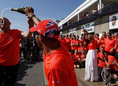 Lewis Hamilton of Britain sprays champagne on McLaren chief Ron Dennis.