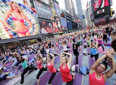 Thousands of yoga enthusiasts convene in New York's Times Square to mark the summer solstice today, as temperatures hit 37 degrees celciuscted to be near 100 degrees (37C) Wednesday.