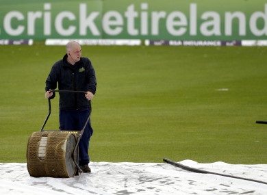 A groundsman attempts to clear the water at Storment.