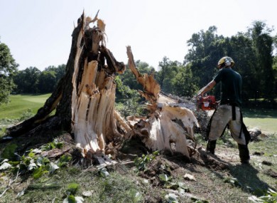 A man uses a chainsaw to clear a storm-felled tree from a golf course in Bethesda, Maryland today.