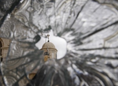 A church dome is seen through a broken window of the Sednaya Convent, which was damaged by artillery fire in Sednaya, north of Damascus, Syria