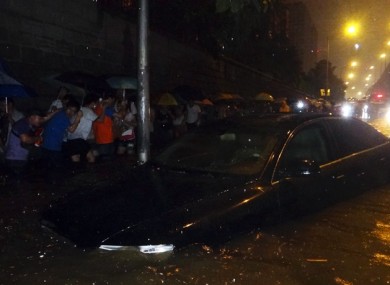 Residents at Shuanging in Beijing make their way across a flooded road