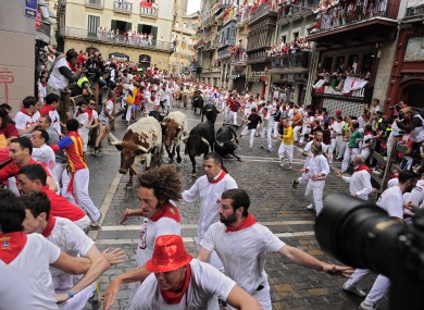 Revelers run on the Estafeta corner with Dolores Aguirre Yabarra ranch bulls during the first running of the bulls at the San Fermin fiestas, in Pamplona northern Spain.