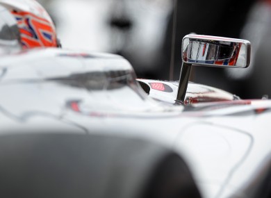McLaren driver Jenson Button is reflected in the rear mirror of his car during the first training session of the Formula One in Hockenheim, Germany this morning.