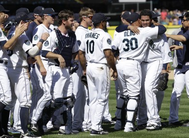 Teammates congratulate Seattle Mariners pitcher Felix Hernandez.